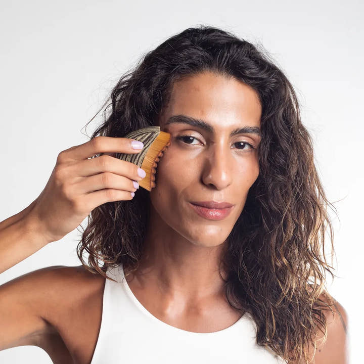 Mujer usando el cepillo en el rostro