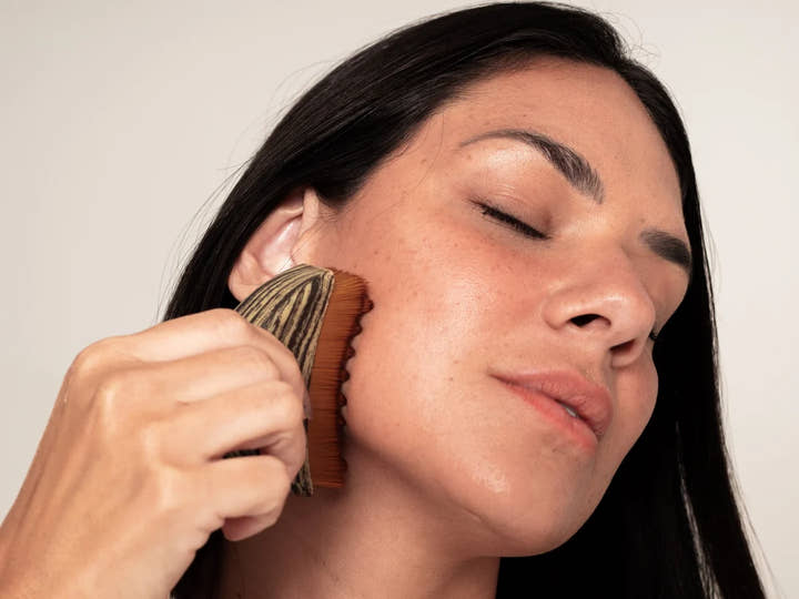 Mujer pasando el cepillo por el pómulo